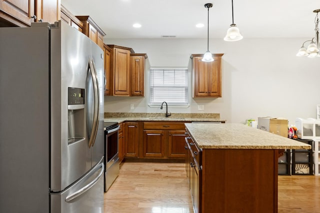 1190 Stonegate Cir NW, Cleveland, TN 37312 - kitchen with stainless steel appliances, a sink, a center island, light wood finished floors, and brown cabinets