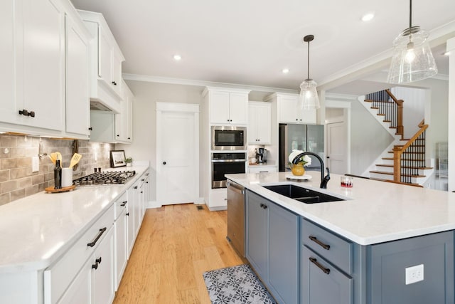 11769 Milton St, Milton, TN 37118 - kitchen with appliances with stainless steel finishes, a sink, light wood-style flooring, white cabinets, and crown molding