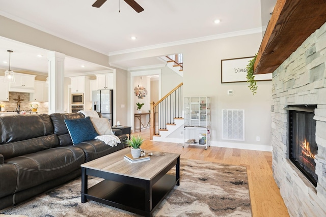 11769 Milton St, Milton, TN 37118 - living room with stairway, light wood-style flooring, a ceiling fan, ornamental molding, and a fireplace