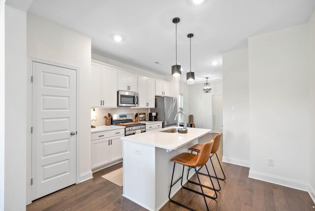 967 Nance Ln, Lebanon, TN 37087 - kitchen with stainless steel appliances, a center island with sink, white cabinets, dark wood finished floors, and a breakfast bar