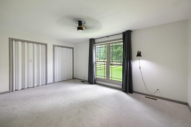 5904 S New Hope Rd, Hermitage, TN 37076 - unfurnished bedroom featuring light carpet, baseboards, ceiling fan, and two closets