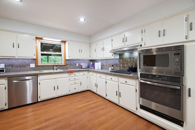 5904 S New Hope Rd, Hermitage, TN 37076 - kitchen with appliances with stainless steel finishes, a sink, decorative backsplash, light wood finished floors, and white cabinetry