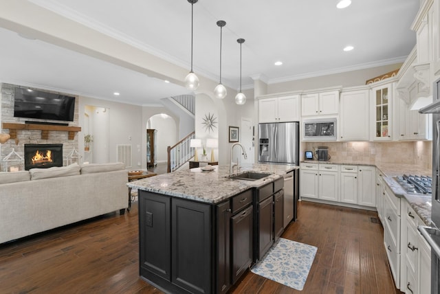 410 Pastoral Way, Nolensville, TN 37135 - kitchen featuring a sink, appliances with stainless steel finishes, arched walkways, open floor plan, and white cabinetry