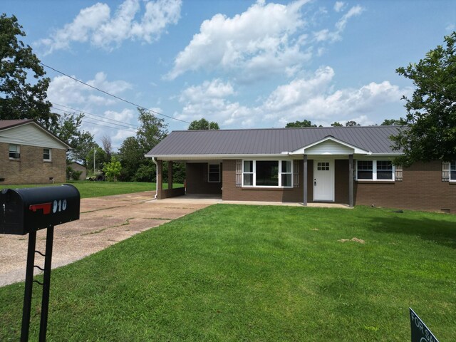 910 Hassell Dr, Waynesboro, TN 38485 - ranch-style house with driveway, an attached carport, metal roof, and a front lawn