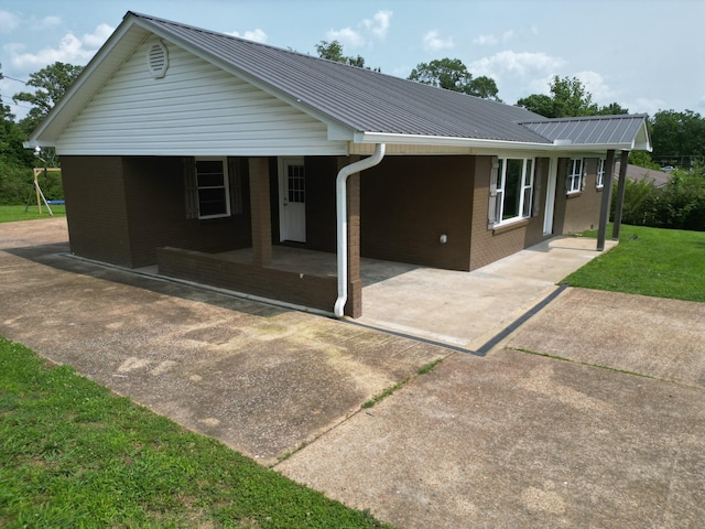 910 Hassell Dr, Waynesboro, TN 38485 - view of front of property with brick siding, metal roof, and driveway