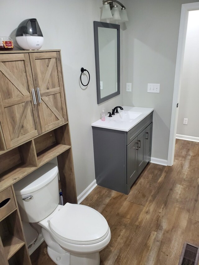 910 Hassell Dr, Waynesboro, TN 38485 - bathroom with vanity, toilet, wood finished floors, and baseboards