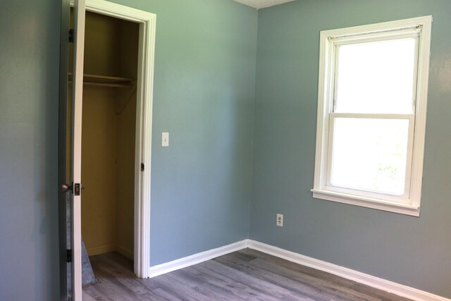 90 Laurel Ln, Paris, TN 38242 - unfurnished bedroom with dark wood finished floors, baseboards, and a closet