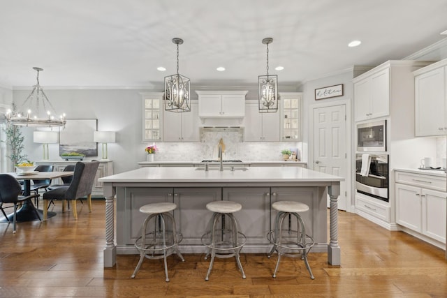 1018 Buddleia Ln, Franklin, TN 37067 - kitchen with stainless steel oven, a chandelier, ornamental molding, a kitchen breakfast bar, and recessed lighting