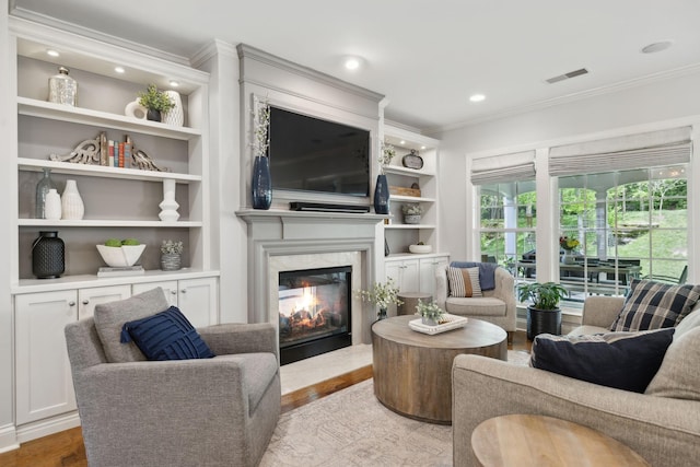 1018 Buddleia Ln, Franklin, TN 37067 - living area with crown molding, a premium fireplace, built in features, wood finished floors, and recessed lighting
