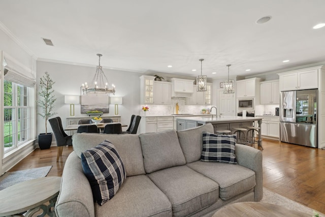 1018 Buddleia Ln, Franklin, TN 37067 - living area with a chandelier, recessed lighting, ornamental molding, and wood finished floors