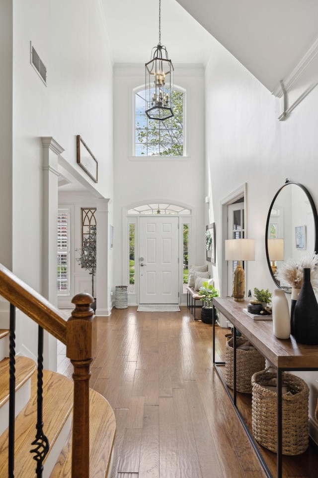 1018 Buddleia Ln, Franklin, TN 37067 - entryway with a chandelier, a high ceiling, hardwood / wood-style flooring, ornate columns, and ornamental molding