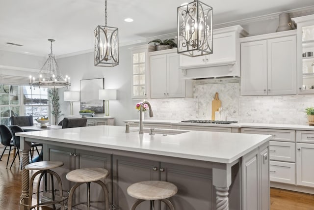 1018 Buddleia Ln, Franklin, TN 37067 - kitchen featuring a sink, a chandelier, a kitchen bar, light countertops, and crown molding