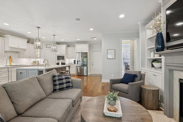 1018 Buddleia Ln, Franklin, TN 37067 - living area with crown molding, light wood-type flooring, recessed lighting, baseboards, and a premium fireplace