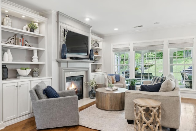 1018 Buddleia Ln, Franklin, TN 37067 - living area featuring ornamental molding, wood finished floors, a high end fireplace, built in features, and recessed lighting