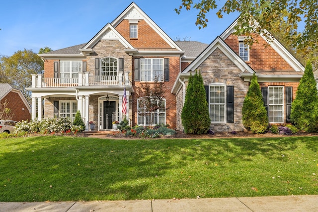 1018 Buddleia Ln, Franklin, TN 37067 - colonial house with a balcony, stone siding, a front lawn, a porch, and brick siding
