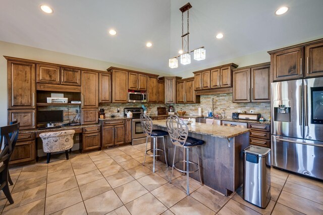 2290 Osburn Rd, Arrington, TN 37014 - kitchen featuring appliances with stainless steel finishes, tasteful backsplash, light stone counters, a breakfast bar area, and recessed lighting