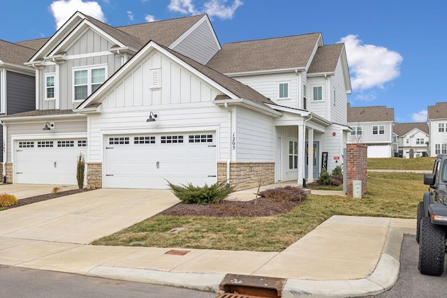 1205 June Wilde Rdg, Spring Hill, TN 37174 - view of front facade featuring stone siding, board and batten siding, a front lawn, concrete driveway, and roof with shingles