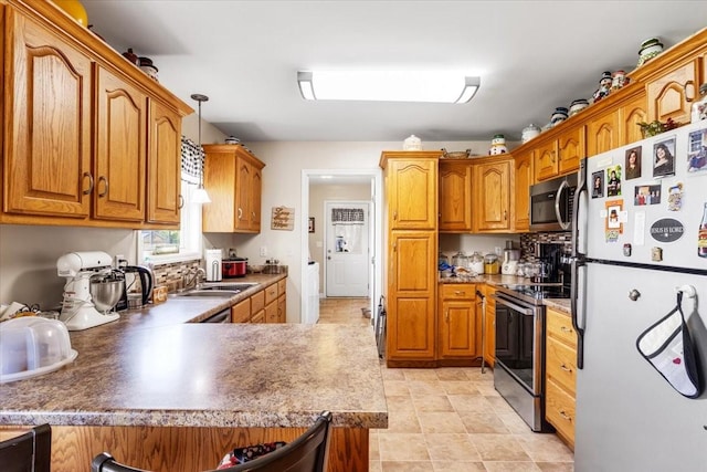 4190 Tanyard Hill Rd, Lynchburg, TN 37352 - kitchen featuring stainless steel appliances, a peninsula, a sink, and brown cabinets