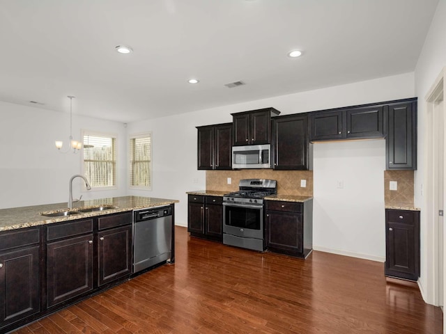 3029 Alan Dr, Spring Hill, TN 37174 - kitchen with appliances with stainless steel finishes, a sink, light stone countertops, backsplash, and recessed lighting