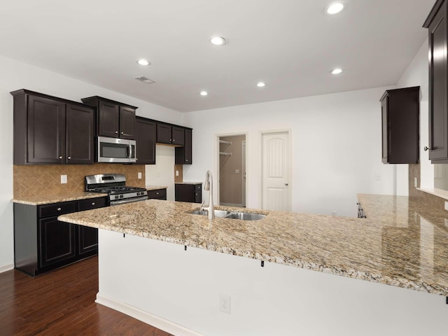 3029 Alan Dr, Spring Hill, TN 37174 - kitchen with appliances with stainless steel finishes, a sink, light stone countertops, dark wood-type flooring, and a peninsula