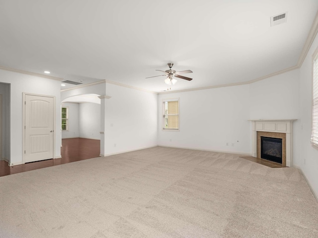 3029 Alan Dr, Spring Hill, TN 37174 - unfurnished living room featuring a ceiling fan, crown molding, arched walkways, carpet flooring, and a fireplace with flush hearth