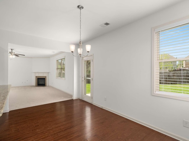 3029 Alan Dr, Spring Hill, TN 37174 - unfurnished living room with a chandelier, a fireplace with flush hearth, dark wood-type flooring, a ceiling fan, and baseboards