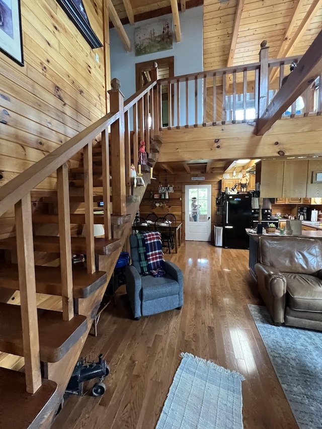 225 Bill Hunter Rd, Celina, TN 38551 - living area with hardwood / wood-style floors, beam ceiling, wood walls, stairway, and a high ceiling