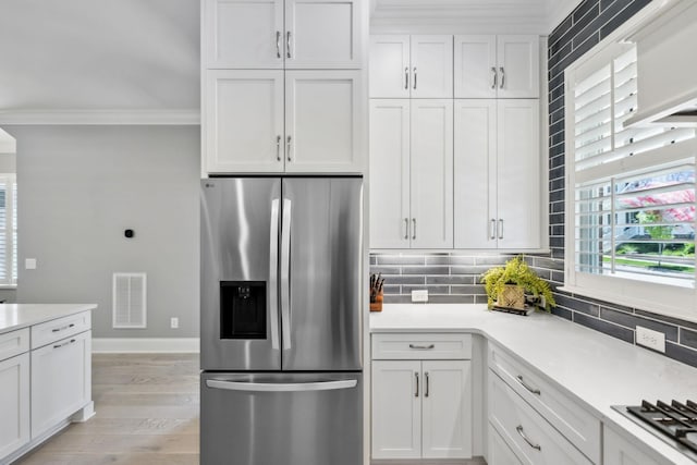 2043 Nathaniel Rd, Franklin, TN 37064 - kitchen with stainless steel appliances, ornamental molding, decorative backsplash, white cabinetry, and light countertops
