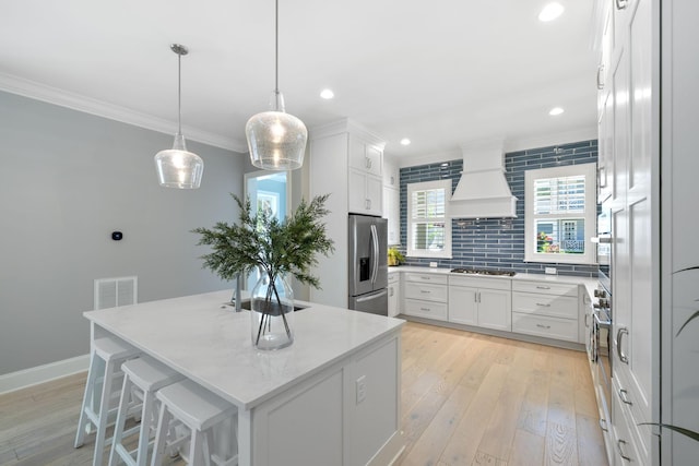 2043 Nathaniel Rd, Franklin, TN 37064 - kitchen featuring premium range hood, appliances with stainless steel finishes, crown molding, backsplash, and white cabinetry