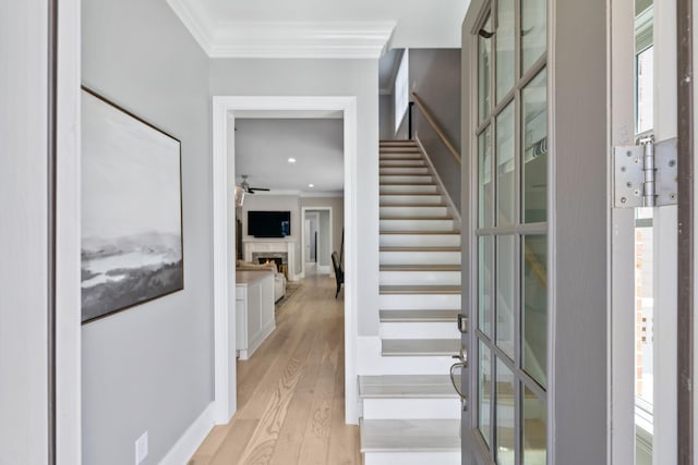 2043 Nathaniel Rd, Franklin, TN 37064 - stairway featuring ornamental molding, wood finished floors, a warm lit fireplace, and baseboards