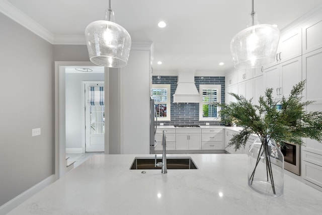 2043 Nathaniel Rd, Franklin, TN 37064 - kitchen with a sink, custom range hood, crown molding, white cabinets, and light stone counters