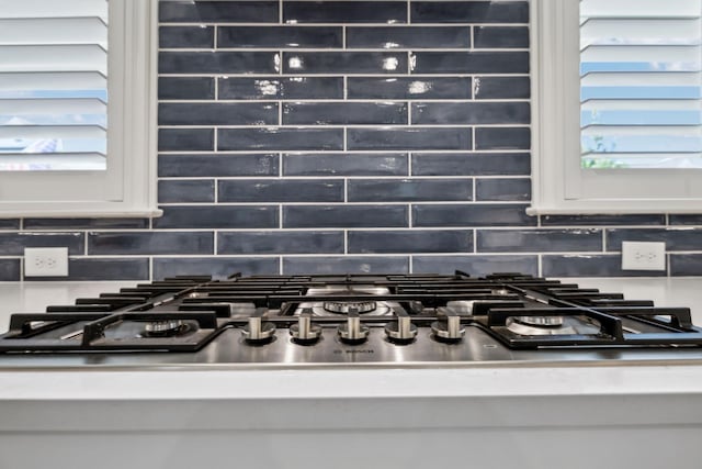 2043 Nathaniel Rd, Franklin, TN 37064 - kitchen view of stainless steel gas stovetop, tasteful backsplash, light countertops, and white cabinetry