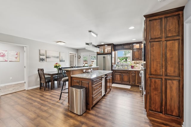 200 Lindsey Hollow Rd, Gallatin, TN 37066 - kitchen featuring stainless steel appliances, a sink, dark wood-style flooring, a kitchen island, and a kitchen breakfast bar