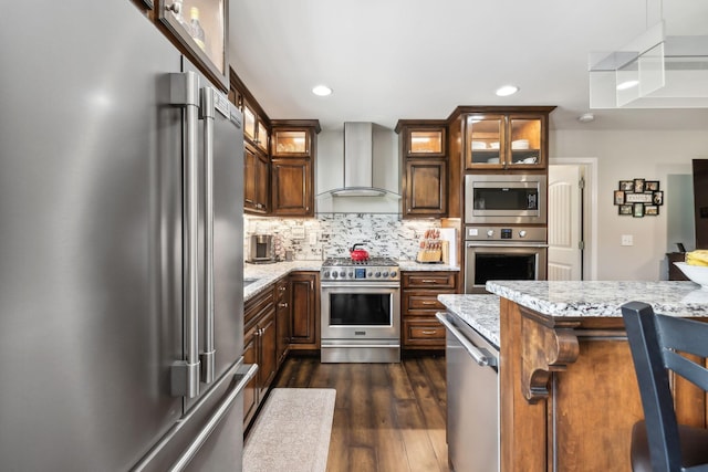 200 Lindsey Hollow Rd, Gallatin, TN 37066 - kitchen with premium appliances, wall chimney range hood, dark wood-type flooring, tasteful backsplash, and light stone countertops