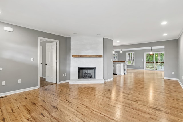 1054 Cragfront Est Loop, Gallatin, TN 37066 - unfurnished living room featuring light wood-style flooring, ornamental molding, recessed lighting, a brick fireplace, and baseboards
