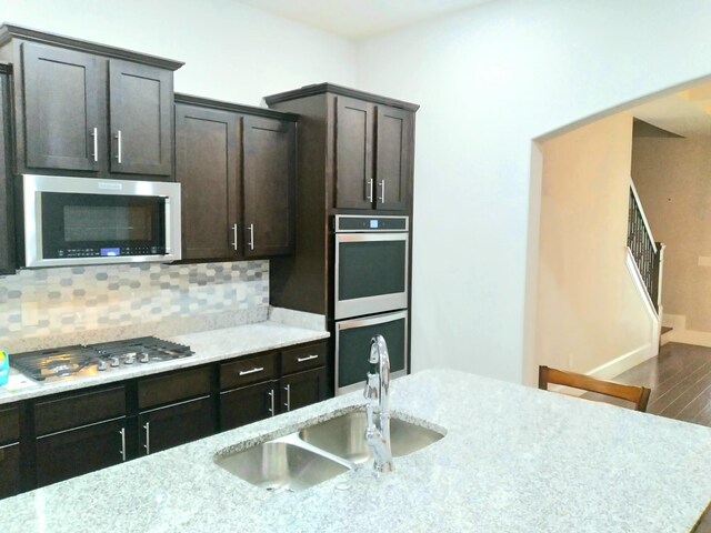 168 Cobbler Cir, Hendersonville, TN 37075 - kitchen featuring stainless steel appliances, a sink, decorative backsplash, wood finished floors, and light stone countertops