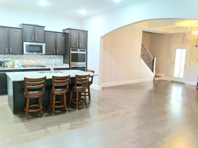168 Cobbler Cir, Hendersonville, TN 37075 - kitchen with stainless steel appliances, arched walkways, decorative backsplash, light countertops, and a chandelier