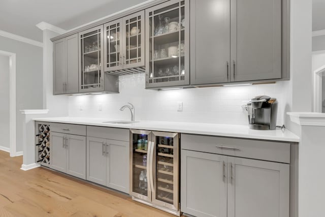 1815 Humphreys Gln, Spring Hill, TN 37174 - bar featuring beverage cooler, ornamental molding, decorative backsplash, a sink, and light wood finished floors