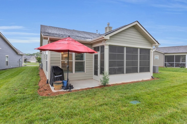 1815 Humphreys Gln, Spring Hill, TN 37174 - back of property with a sunroom, a chimney, a lawn, a patio, and central AC unit