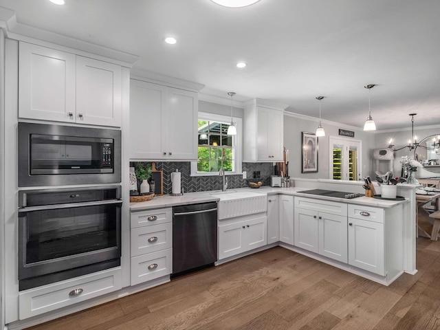 7119 Littlejohn Ln, Fairview, TN 37062 - kitchen featuring appliances with stainless steel finishes, a peninsula, ornamental molding, white cabinetry, and tasteful backsplash