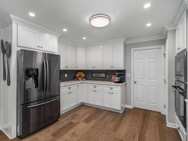 7119 Littlejohn Ln, Fairview, TN 37062 - kitchen featuring stainless steel refrigerator with ice dispenser, light countertops, black oven, white cabinetry, and ornamental molding
