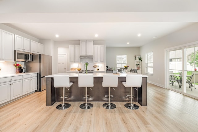 3232 Firerock Dr, Murfreesboro, TN 37128 - kitchen with stainless steel appliances, light wood-style flooring, an island with sink, recessed lighting, and a kitchen bar