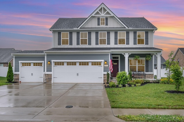 3232 Firerock Dr, Murfreesboro, TN 37128 - view of front of home with a porch, board and batten siding, a front lawn, concrete driveway, and stone siding