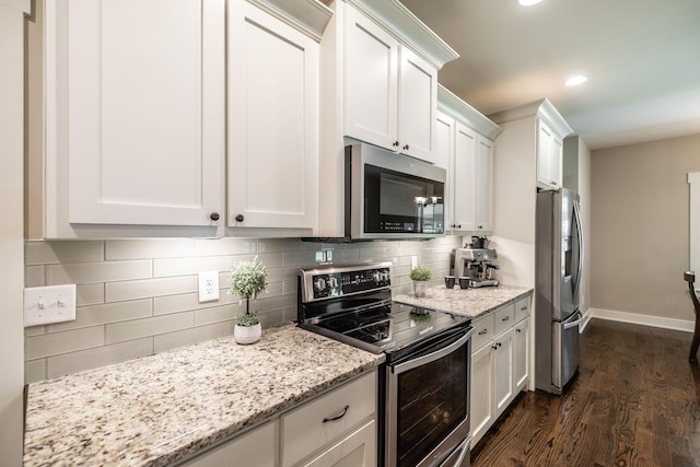 725B N Russell St, Portland, TN 37148 - kitchen featuring stainless steel appliances, dark wood-style floors, white cabinets, tasteful backsplash, and baseboards