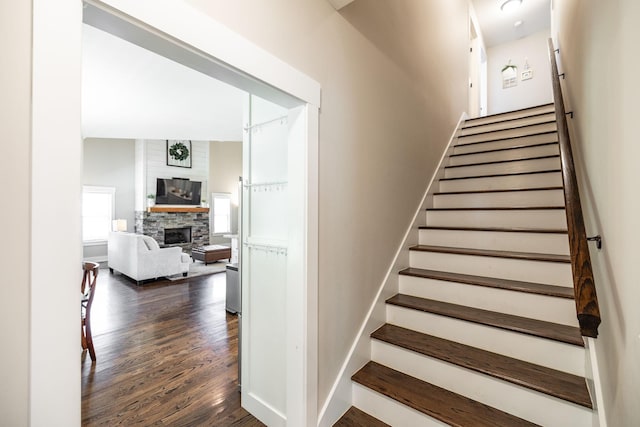725B N Russell St, Portland, TN 37148 - staircase with wood finished floors, a stone fireplace, and baseboards