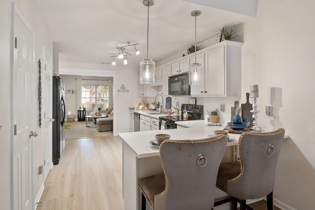 2020 Caladonia Way, Smyrna, TN 37167 - kitchen featuring black appliances, light countertops, a sink, a peninsula, and a kitchen bar
