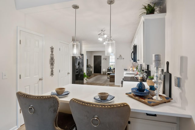 2020 Caladonia Way, Smyrna, TN 37167 - kitchen featuring black appliances, white cabinetry, a breakfast bar area, pendant lighting, and light countertops