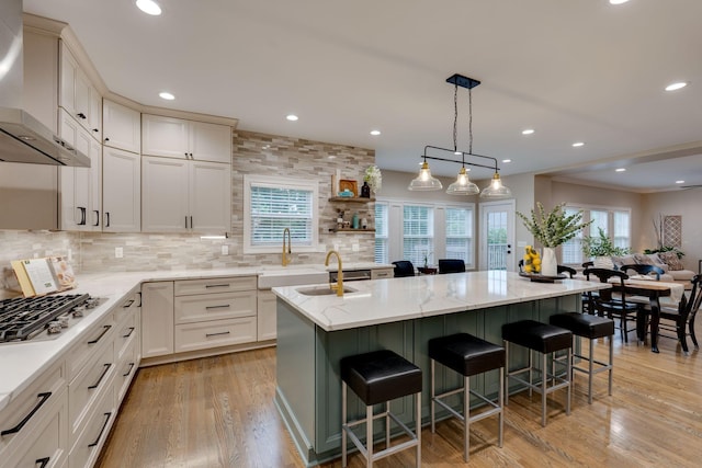3168 Appian Way, Spring Hill, TN 37174 - kitchen featuring wall chimney exhaust hood, stainless steel gas stovetop, a sink, an island with sink, and healthy amount of natural light