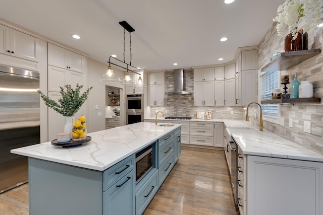 3168 Appian Way, Spring Hill, TN 37174 - kitchen with wall chimney exhaust hood, built in appliances, a sink, decorative backsplash, and light wood-type flooring