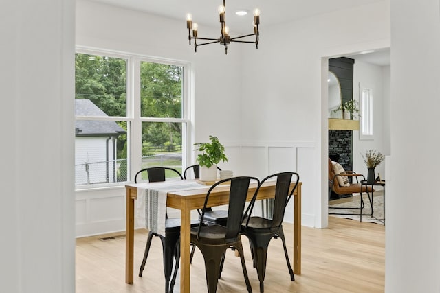 1775 Hayshed Rd, Charlotte, TN 37036 - dining room with a chandelier, a decorative wall, light wood-style flooring, and wainscoting